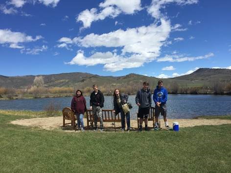 Five students at a lake with fishing poles